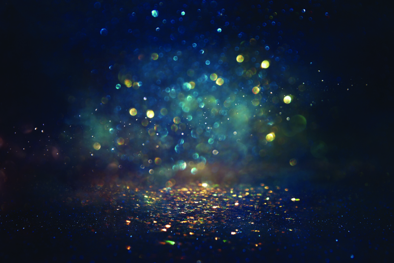 background of abstract glitter lights. gold, blue and black. de focused