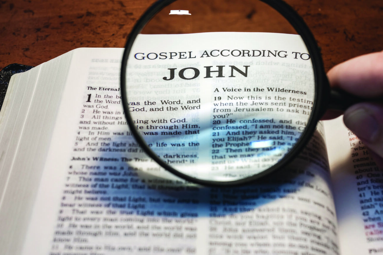 title page book of John close up using magnifying glass in the b